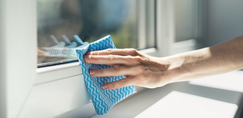 Ventanas brillantes y sin marcas con el limpiacristales de mano